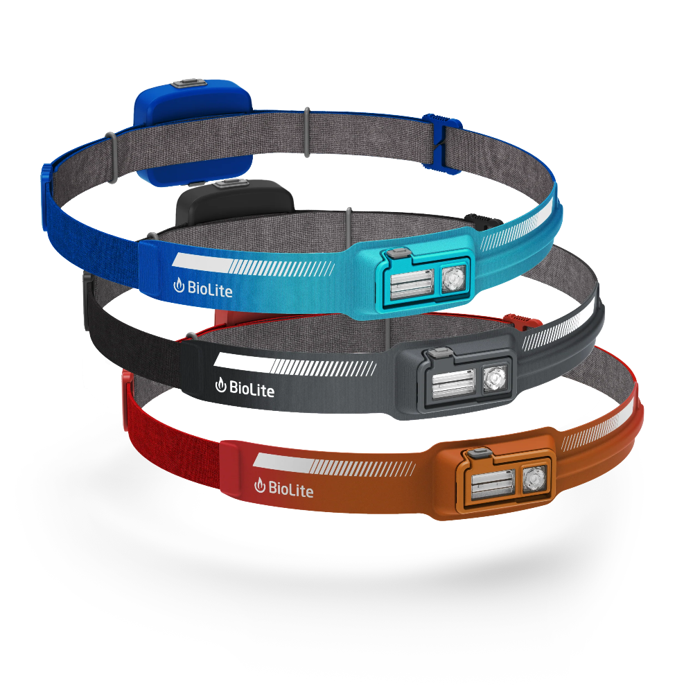 Drie BioLite HeadLamp 440 hoofdlampen gestapeld: blauw, zwart en oranje, elk met accupack aan achterzijde en logo voorop.