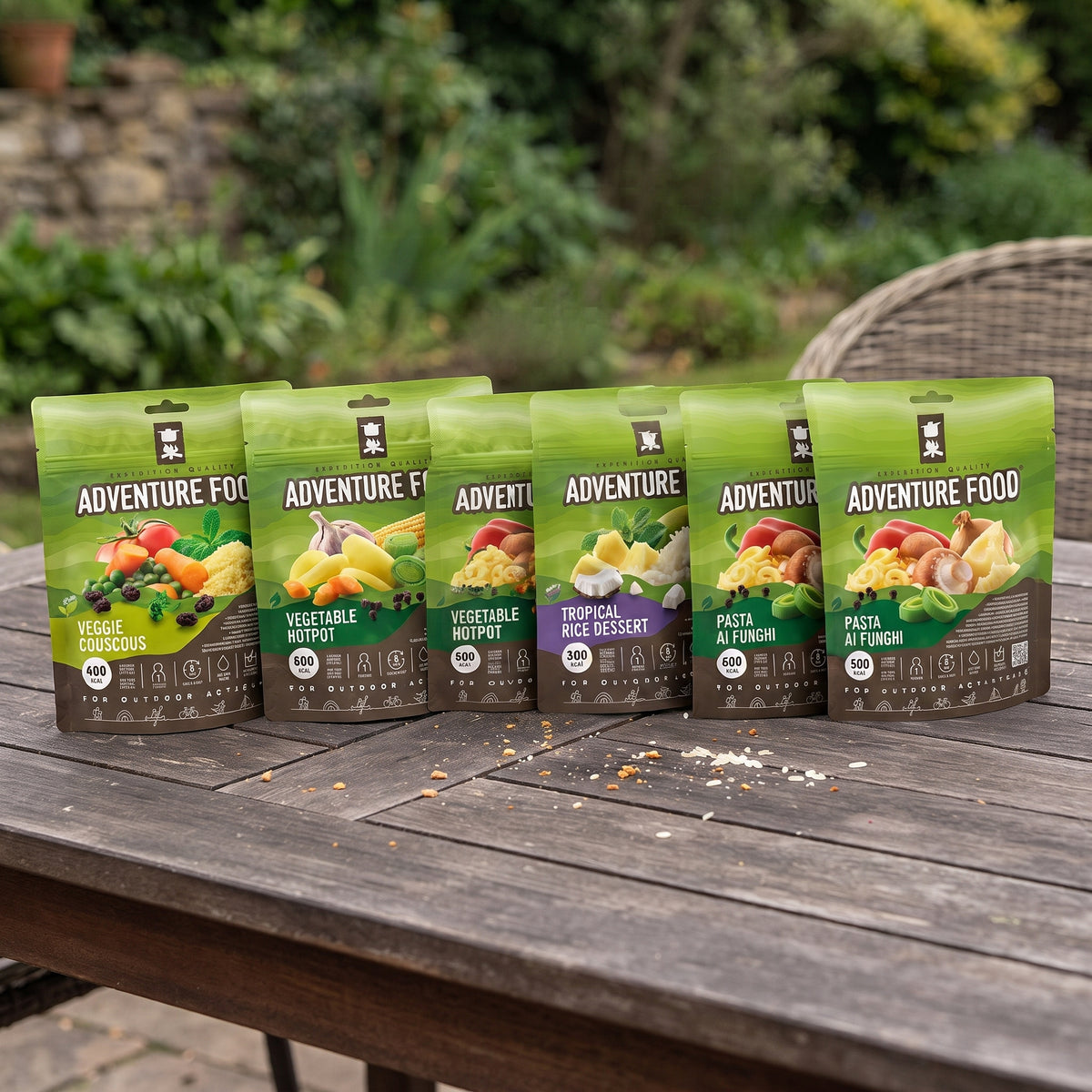 Adventure Food assortiment gevriesdroogde maaltijden in groene stazakken op een houten tafel