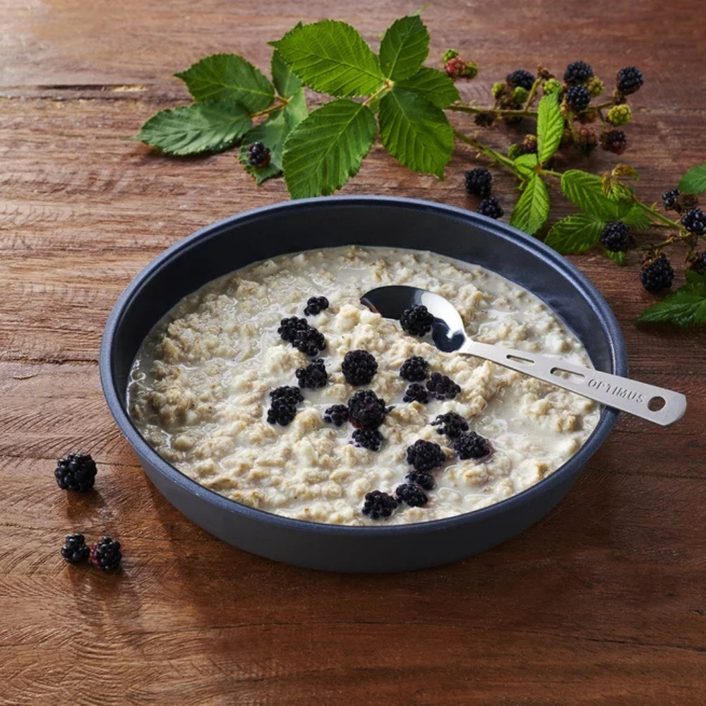 Trek n Eat Protein Porridge stazak tijdens een pauze in de natuur met een lepel en gevriesdroogde havermoutmaaltijd